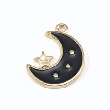 close up of a gold and black jewelry pendant shaped like a moon