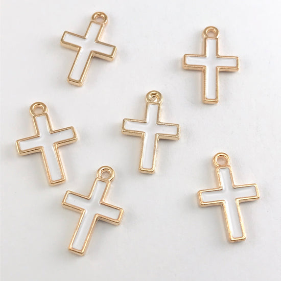 white and gold cross shaped jewelry charms