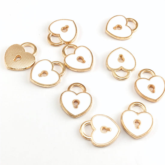 white and gold colour jewelry charms that are shaped like locks with a keyhole