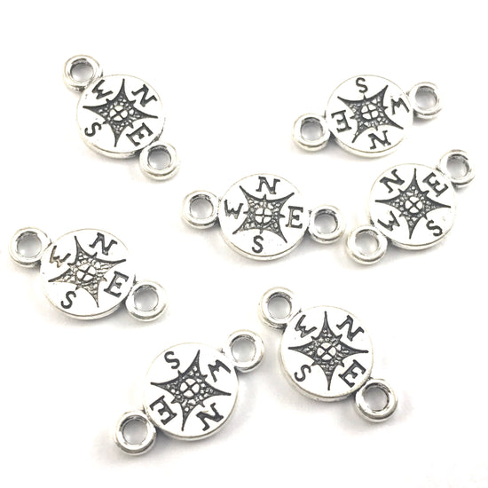 silver colour jewerly charms that look like compasses 