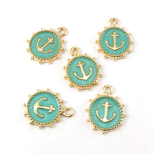 green and gold jewelry charms that look like anchors