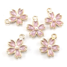 purple and gold jewerly charms in the shape of flowers
