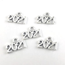 silver jewerely charms shaped in the numbers 2021