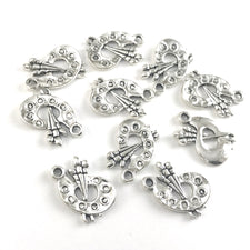 silver colour jewerly charms shaped like a painters palette with brushes
