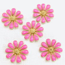 5 metal jewelry charms shaped like daisies and colored gold and pink