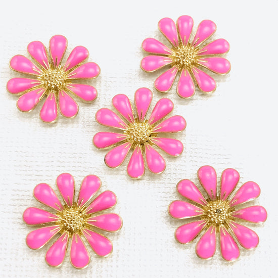 5 metal jewelry charms shaped like daisies and colored gold and pink