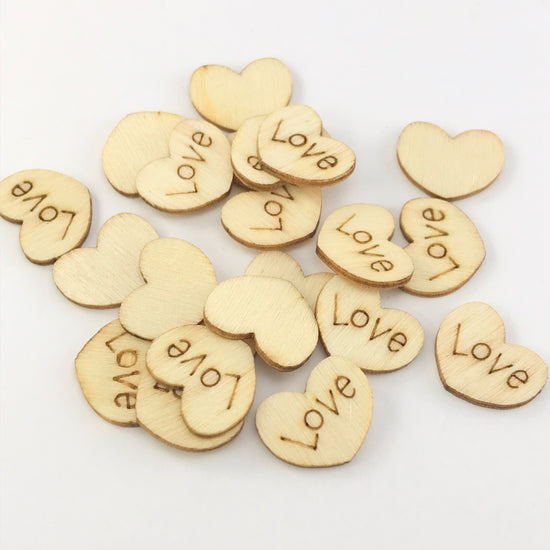 heart shaped wooden pieces with the word love engraved on them