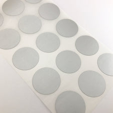 silver colour round stickers on a sheet of paper