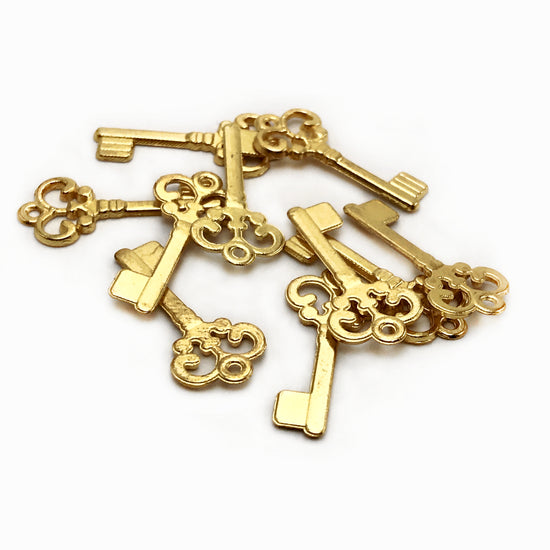 gold colour jewelry charms that are shaped like keys