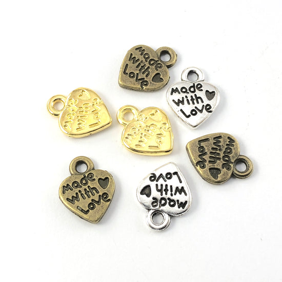 heart shaped jewelry charms with the words made with love on them