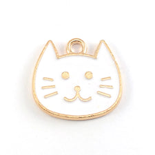 white and gold jewerly charm that looks like a cat face