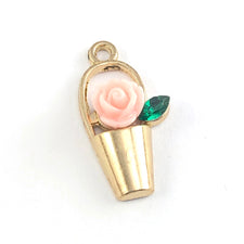 gold, pink and green jewerly charm that looks like a flower basket