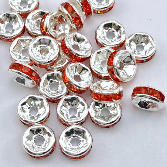 pile of silver and orange color rondelle jewelry beads