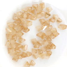 beige jewerly beads that are triangle shape
