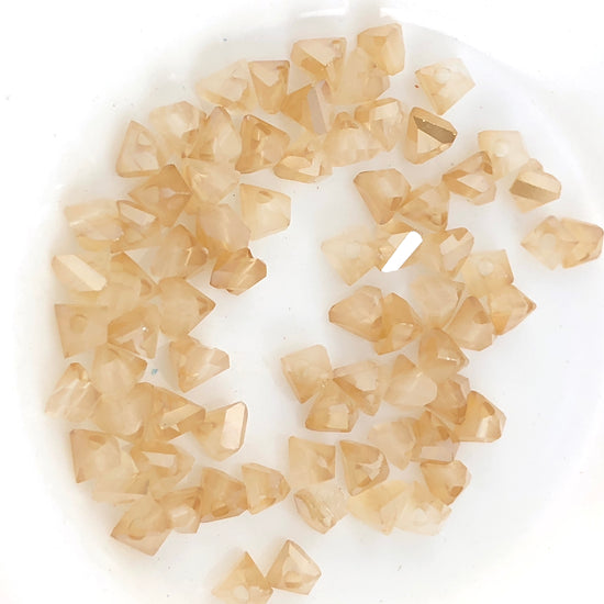 beige jewerly beads that are triangle shape