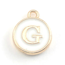 round white and gold jewerly charm with the letter G on it