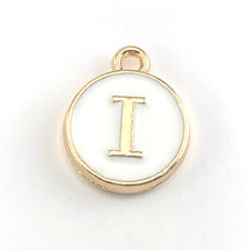 round white and gold jewerly charm with the letter I on it