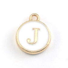 gold jewerly charm with the letter J on it