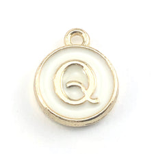 gold and white round jewerly charms with the letter Q on them