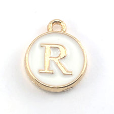 gold and white round jewerly charms with the letter R on them