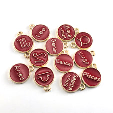 red and gold round jewerly charms with zodiac signs on them
