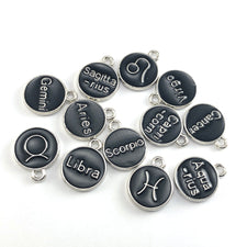 black and silver jewerly charms with zodiac signs on them