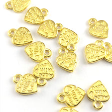 heart shaped gold jewelry charms with the words made with love on them
