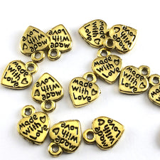 heart shaped gold jewelry charms with the words made with love on them