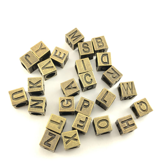 square bronze colour beads with letters on them