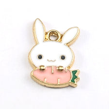 gold, white and pink jewerly charms shaped like a rabbit holding a carrot