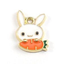 gold, white and orange jewerly charms shaped like a rabbit holding a carrot