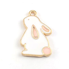 gold, white and pink jewerly charms shaped like a rabbit