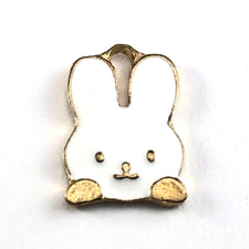 gold and white jewerly charms shaped like a rabbit