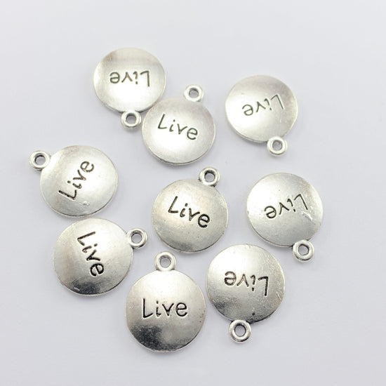 Nine silver round jewelry charms with the word Live on them