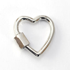 silver heart shaped jewerly pendant with a screw carabiner on one side