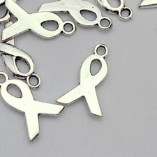 silver jewerly charms in the shape of awareness ribbons