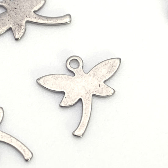 silver jewelry charm shaped like a dragonfly