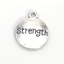 round silver jewerly charm with the word strength on it