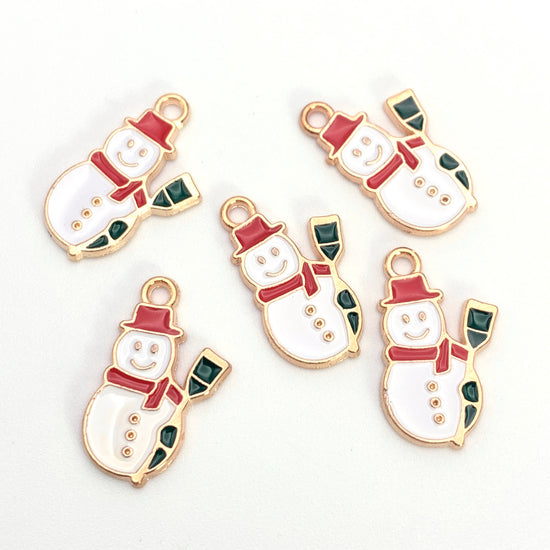 Five white, green, red, and gold snowman shaped jewelry charms