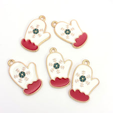 Five white red gold and green jewelry charms shaped like mittens