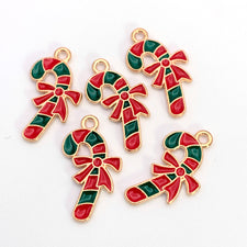 Five red white and gold colour jewelry charms shaped like candy canes with a bow knot
