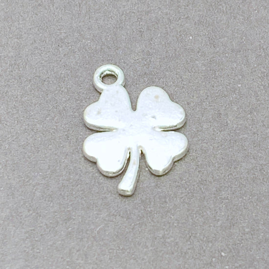 silver colour jewerly charm in the shape of a four leaf clover