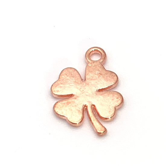 rose gold colour jewerly charm in the shape of a four leaf clover