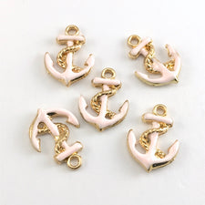 pink and gold jewelry charms shaped like anchors