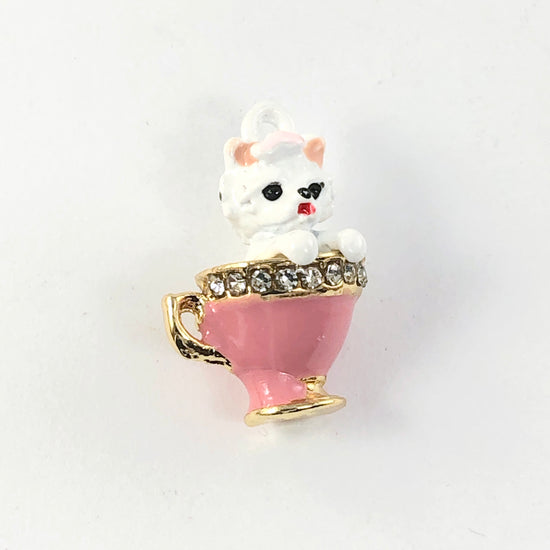Jewelry charms that look like a white dog in a pink teacup with rhinestones around the rim of the cup