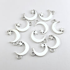 silver colour jewerly charms shaped like quarter moons with a star attached