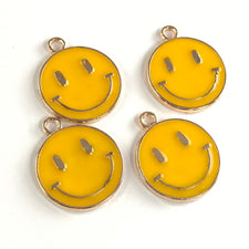 yellow and gold round flat jewerly charms that have a smiley face on them